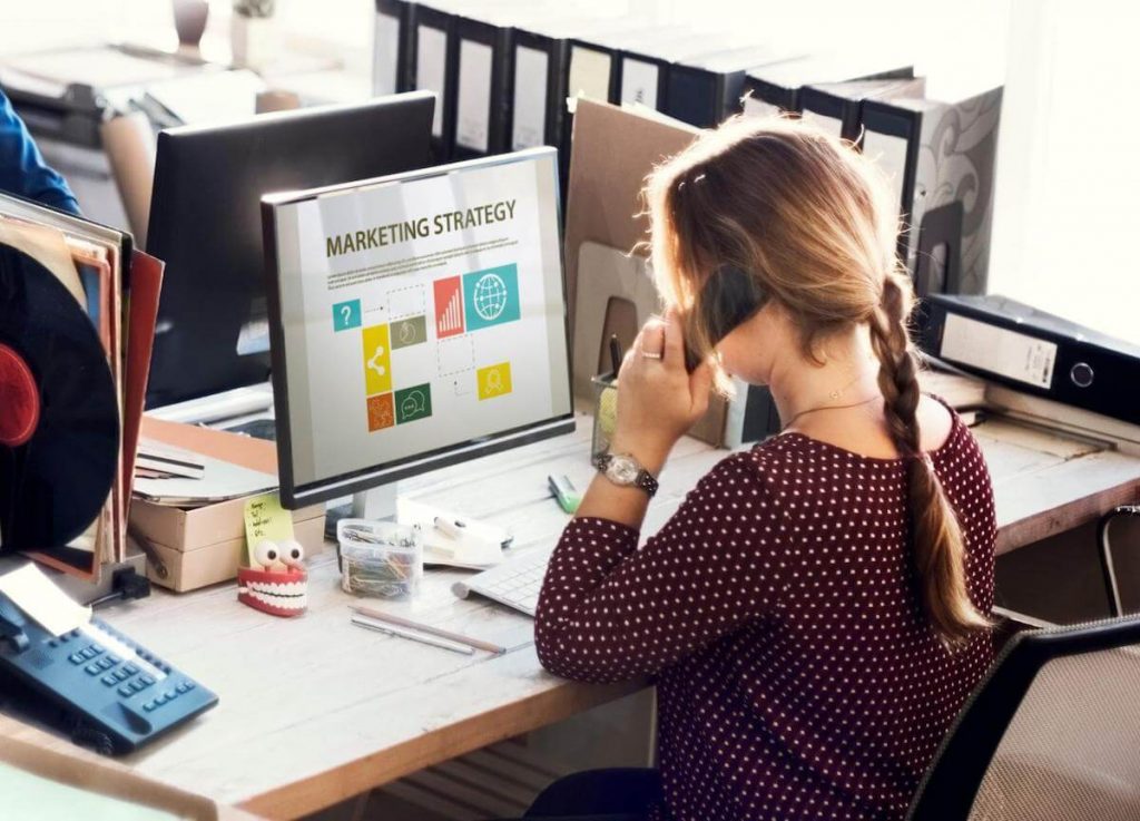 Campaigns management: person on the phone while looking at a Marketing Strategy