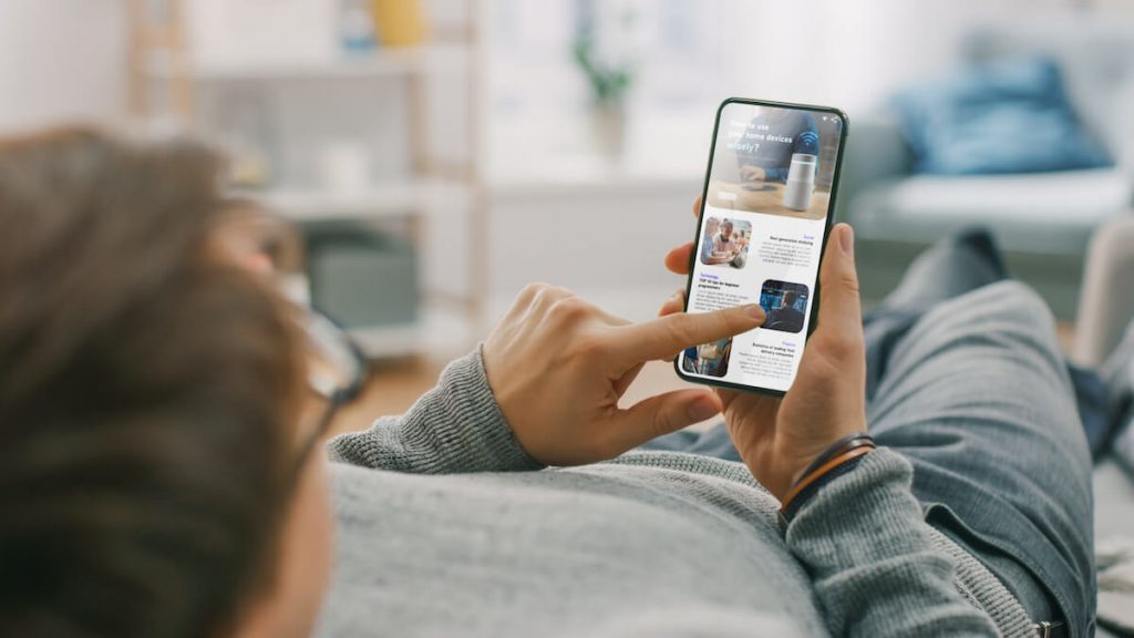 Branded content: man lying in his couch while scrolling through his phone