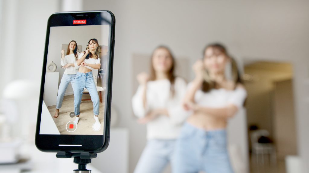 two women filming a TikTok video
